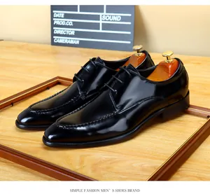 Macro view of glossy black patent leather men's formal shoes with lace-up detail