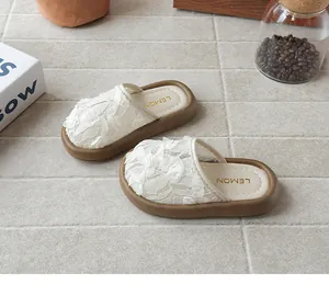 Primer plano de pantuflas de encaje blanco para niñas con detalles de rosas en 3D.