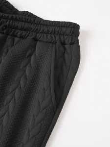 Detailopname van zwarte jacquard gebreide short met elastische tailleband en zijzak.