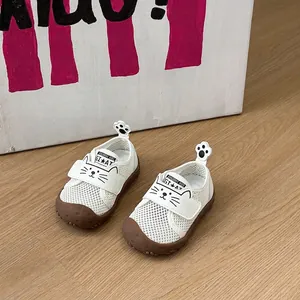 Gros plan sur des chaussures bébé en maille respirante blanche avec motif chat
