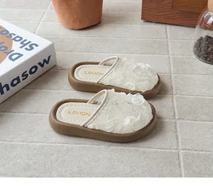 Primer plano de zapatillas de encaje para niña con rosas y suelas gruesas marrones