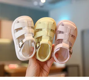 Detailopname van zomerse baby sandalen in wit, geel en roze met verstelbare gespbandjes