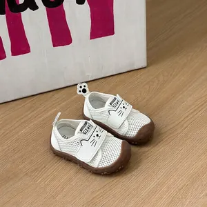 Détail de chaussures de marche en mesh blanc pour bébé avec un joli visage de chat