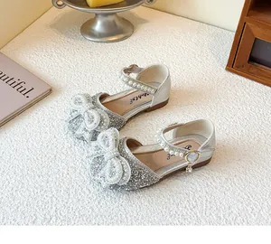 Detail of silver girl's princess shoes featuring a sparkly bow and pearl strap.