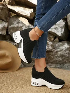 Detailaufnahme von schwarzen Flyknit-Slip-on-Sneakern mit Plateausohle am Modell.