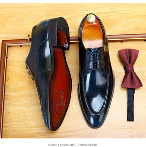 Detailed view of shiny patent leather men's formal dress shoes with moc-toe stitching
