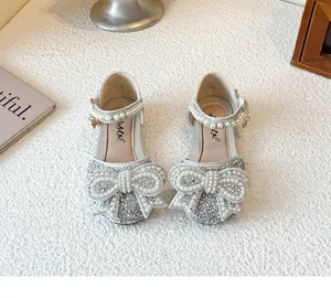 Macro view of sparkly silver children's princess shoes with ornate pearl bow detail