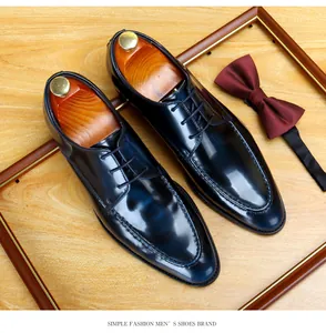 Close-up of navy blue glossy leather men's dress shoes with a classic maroon bow tie