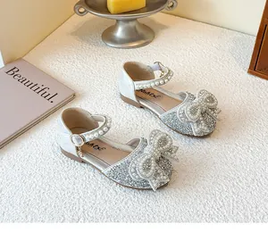 Detail of silver glitter girl's princess shoes with pearl encrusted bow and strap