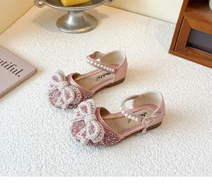 Detail of pink glitter girls princess shoes featuring a large pearl bow and ankle strap