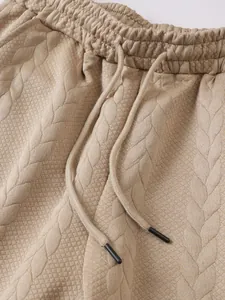 Gedetailleerde weergave van de beige jacquard gebreide korte broek tailleband met koord