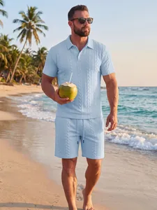 Lichtblauw jacquard gebreid poloshirt en bijpassende short voor heren op het strand.