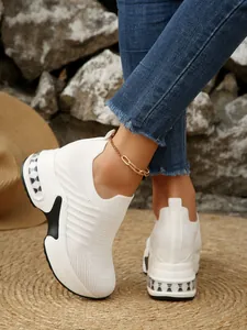Nahaufnahme weißer Strick-Slipper für Damen mit Plateausohle in einer Außenumgebung
