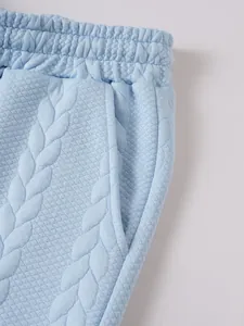 Detailopname van lichtblauwe jacquardstof met focus op de tailleband en zakken voor heren