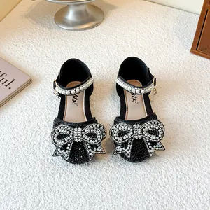 Elegant black girls princess shoes with rhinestone bow and pearl straps.
