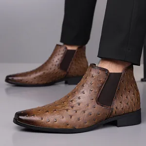 Gros plan détaillé de bottines Chelsea marron pour hommes avec motif autruche et bout carré.