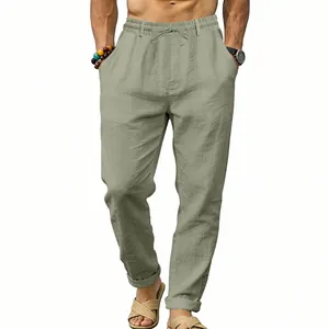 Detail of men's sage green linen straight-leg trousers with drawstring waist.