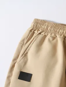 Détail de short tissé beige pour homme avec taille élastique et poche