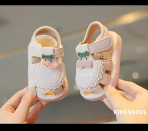 Primo piano di graziosi sandali rosa per neonata con decoro a ciliegia e ricamo 'Love You'
