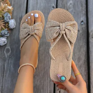 Detalle de sandalias planas de lino con lazo para verano y suela de cuerda de yute