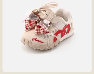 Close-up of toddler girls mesh sneaker with red plaid bow and heart detail.