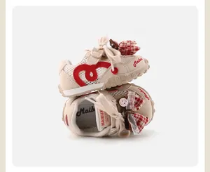 Detailed view of baby girl mesh sneakers with cute red plaid bow and breathable upper