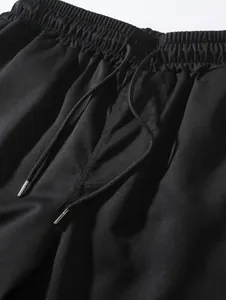 Vue détaillée de la taille élastique et du cordon sur un short tissé noir pour homme