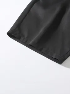 Gros plan montrant les coutures de l'ourlet du short de plage tissé noir homme
