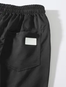 Gros plan de la taille élastique et de la poche arrière sur un short de plage tissé noir