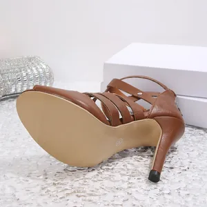 Detailansicht braune Stiletto-Sandaletten mit Nieten und Sohle in Größe 36 für Damen.