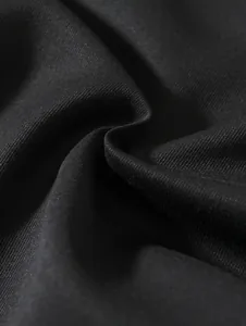 Gros plan sur la texture du tissu tissé noir de qualité pour shorts de plage décontractés.