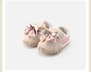 Close-up view of stylish pink baby girls' mesh sneakers featuring cute lace bow accents.