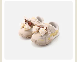 Side detail of beige toddler girl sneakers with mesh panels and yellow bow
