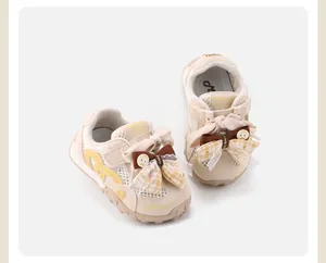 Detailed view of beige baby girl mesh sneakers featuring cute bows and lace trim