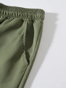 Détail de short tissé pour homme vert olive avec taille élastique et poche latérale.
