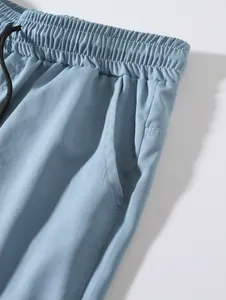 Vue détaillée de la taille et de la poche d'un short de sport en tissu bleu clair pour hommes