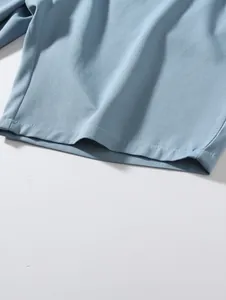 Gros plan sur le tissu tissé bleu clair et les coutures de l'ourlet du short de plage
