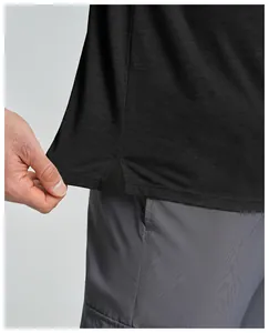 Nahaufnahme des Saums eines schwarzen Merino-T-Shirts mit sportlichem Seitenschlitz.