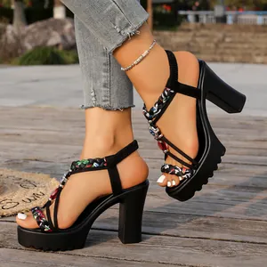 Primer plano de sandalias negras de tacón alto con plataforma y tiras trenzadas de colores