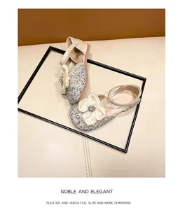 Detail showing champagne glitter girls' princess shoes with large satin bow accent