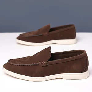Close-up of brown suede loafers featuring elegant stitching and off-white soles