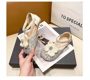 Exquisite detail of girls' glittery princess sandals featuring silk bow and crystal heart