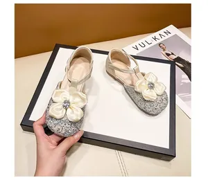 Detailed view of silver glitter girl princess shoes with large floral rhinestone bow.