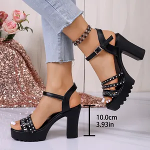 Primer plano de sandalias negras con tacón y plataforma con correas tachonadas
