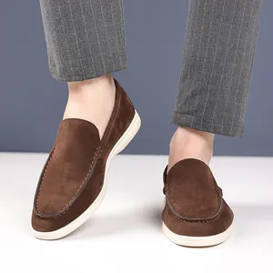 Close-up of stylish men's brown suede loafers worn with elegant grey pinstripe trousers