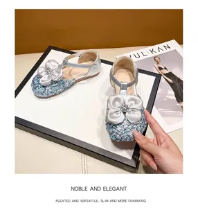Detailed view of silver sparkling girls princess shoes with large ribbon flower