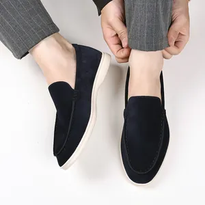 Close-up detail view of navy blue suede loafers worn with grey pinstripe trousers