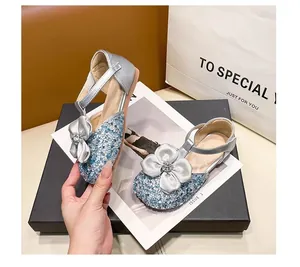Detail of sequined girls' princess sandals featuring a rhinestone-embellished bow