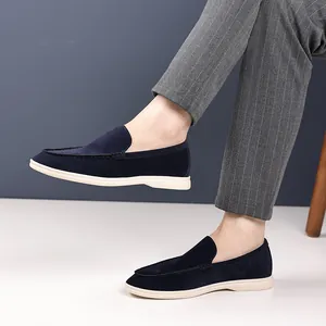 Side view of navy suede loafers for men worn with gray pinstripe trousers