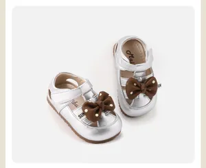 Detail view of silver toddler girl sandals with decorative brown polka-dot bows